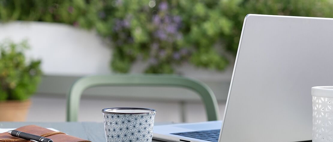 Home Office auf der Terrasse, aufgeklappter Laptop
